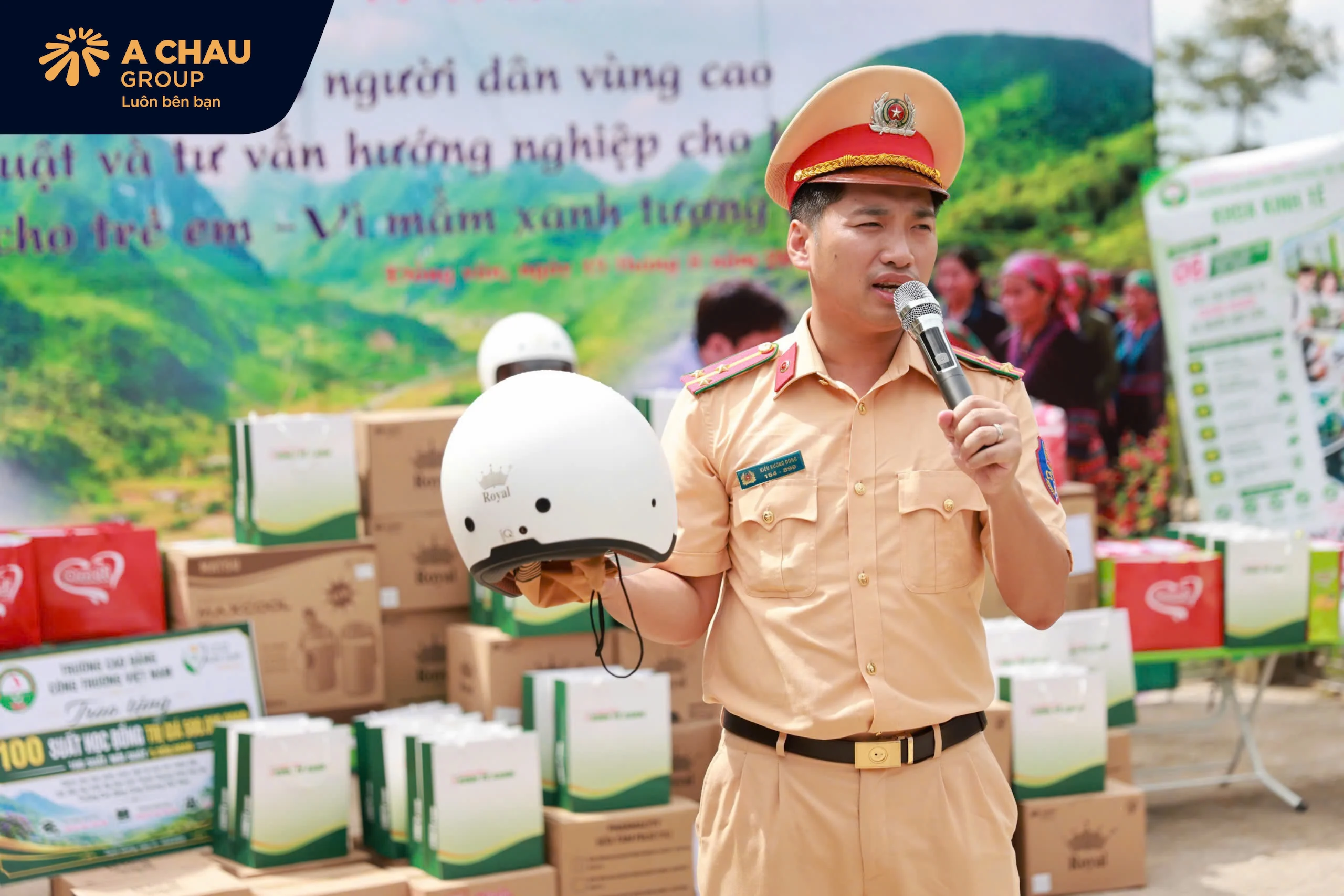Người dân và học sinh được hướng dẫn cách đội mũ bảo hiểm đúng quy cách và nhận mũ Royal M139 từ chương trình.
